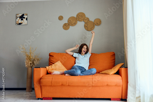 cheerful woman relaxing at home in the room on the couch interior apartments