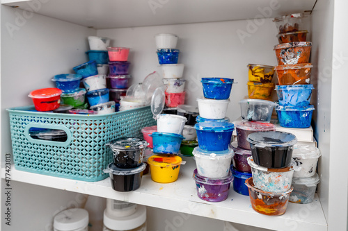 paints and ink in plastic jars on the shelf. Art concept