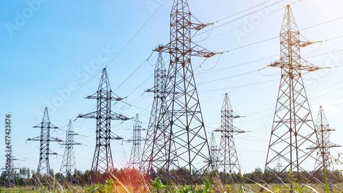 Transmission pylons with high-voltage power lines with copy space. Transmission towers in industrial landscape. High voltage electric transmission towers. Electricity transmission through power lines. photo