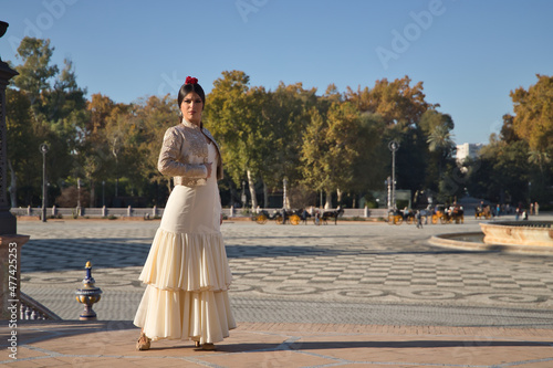 Young flamenco woman, Hispanic and brunette, in typical flamenco dance suit, with bullfighter jacket, posing on a bridge. Concept of flamenco, dancer, typical Spanish dance.
