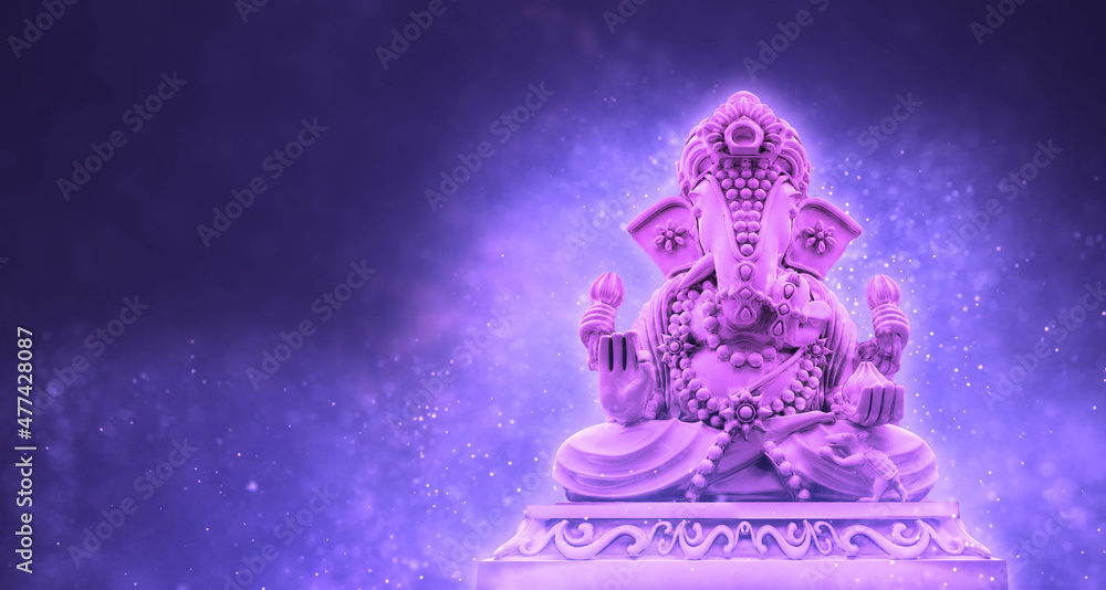 Selective focus on statue of Lord Ganesha, Ganesha Festival. Hindu religion and Indian celebration of Diwali festival concept on dark, red, yellow background.