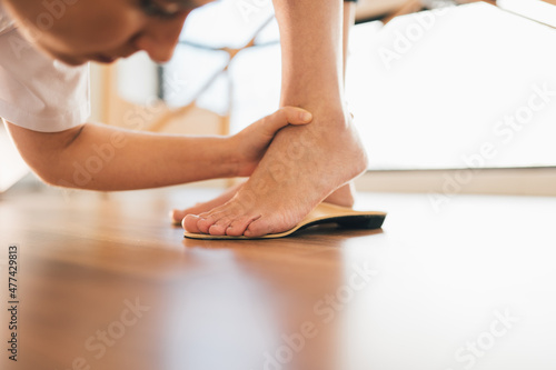 Chiropodist checking the custom foot insole of a patient on the floor in the medical center