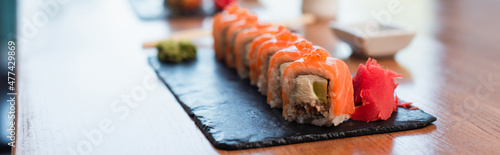 Fotografie, Obraz close up view of black plate with delicious sushi rolls on blurred background, b