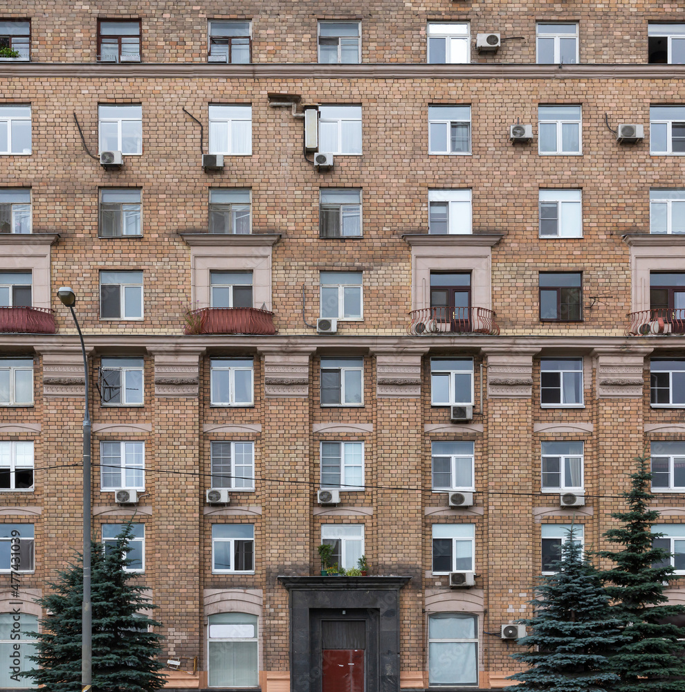 Obraz premium Vintage architecture classical brick facade residential building decorated stucco molding soviet symbolic front view