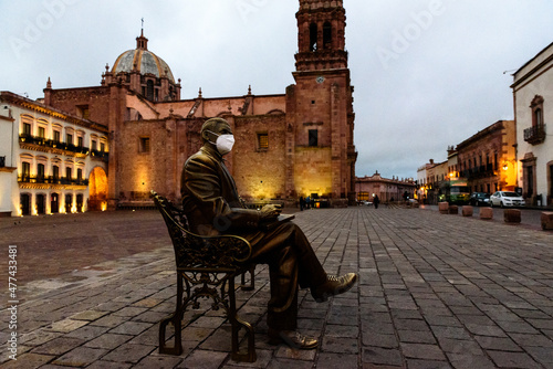 the sculpture of the man sitting at a bench at the Plaza de Armas in the center of Zacatecas, Mexico photo
