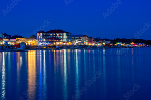 Night lights on the sea shoreline. Resort town view from the sea to the shore.