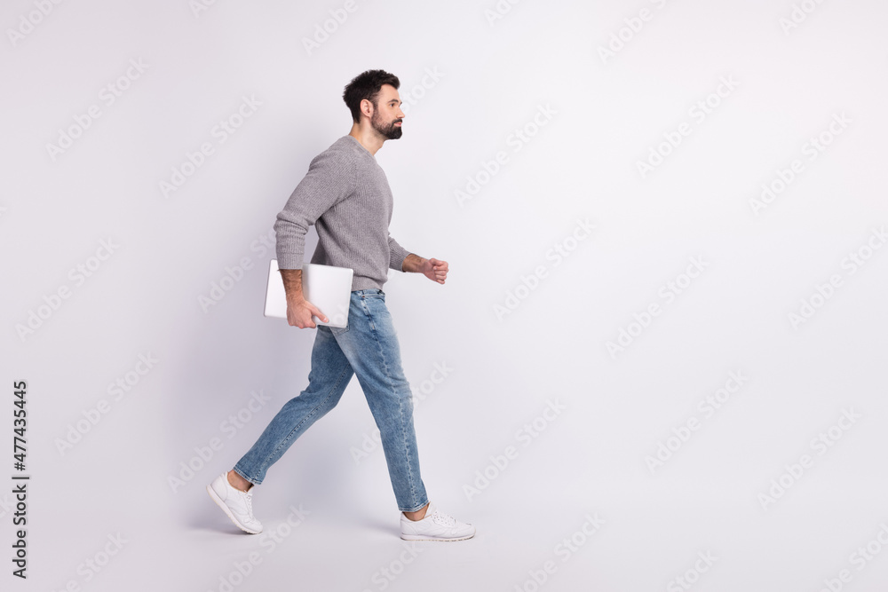 Full body profile side photo of young man walk hold laptop ...