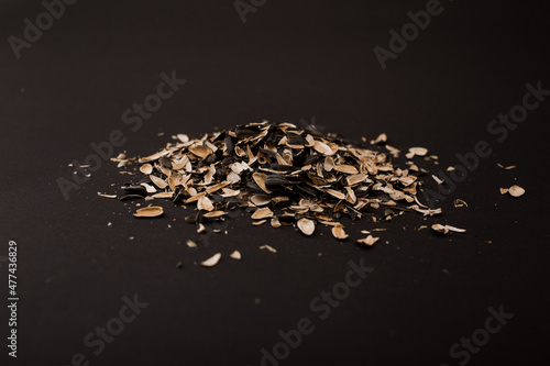 A mountain of husks from under the seeds lies on a black background