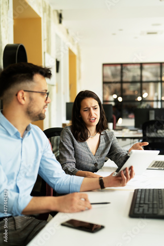 Colleagues in office. Businesswoman and businessman discussing work in office