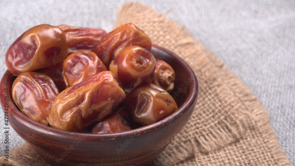 Dates in wooden bowl on background. dried dates fruit. Dates in wooden bowl on background. dried dates fruit.