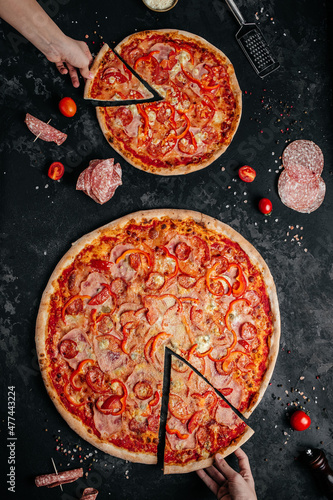 hands grabbing pizza slices. Sliced delicious pepperoni pizza. vertical image. top view. place for text