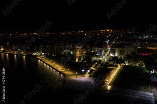Aerial view of the city of Thessaloniki at night with famous White Tower in the background.