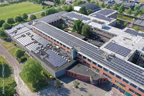 Drone photo of a large school building for vmbo, mavo ,havo and vwo education.
1100 solar panels have been installed on the roof of this school for green energy.