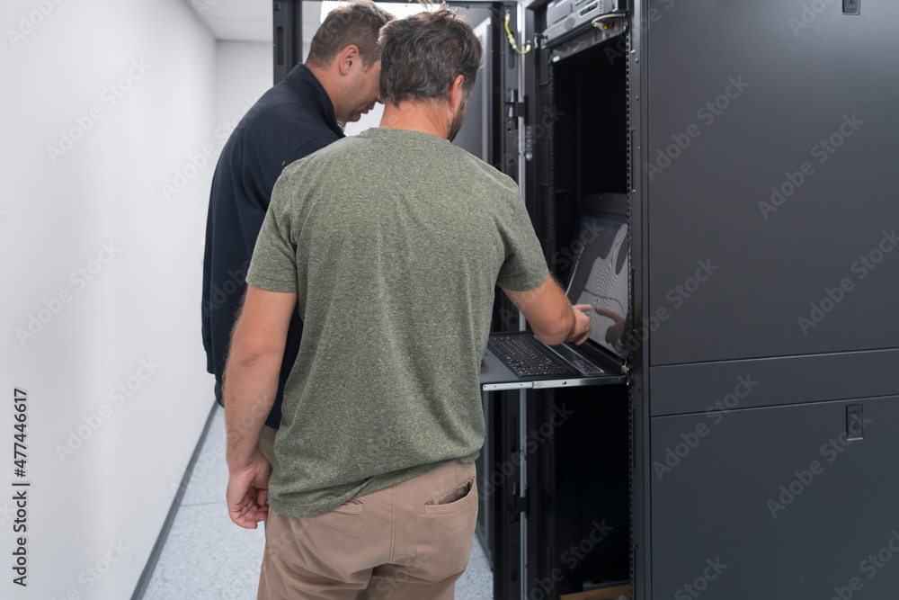 Technicians team updating hardware inspecting system performance in super computer server room or cryptocurrency mining farm. Technicians team updating hardware inspecting system performance in super computer server room or cryptocurrency mining farm.