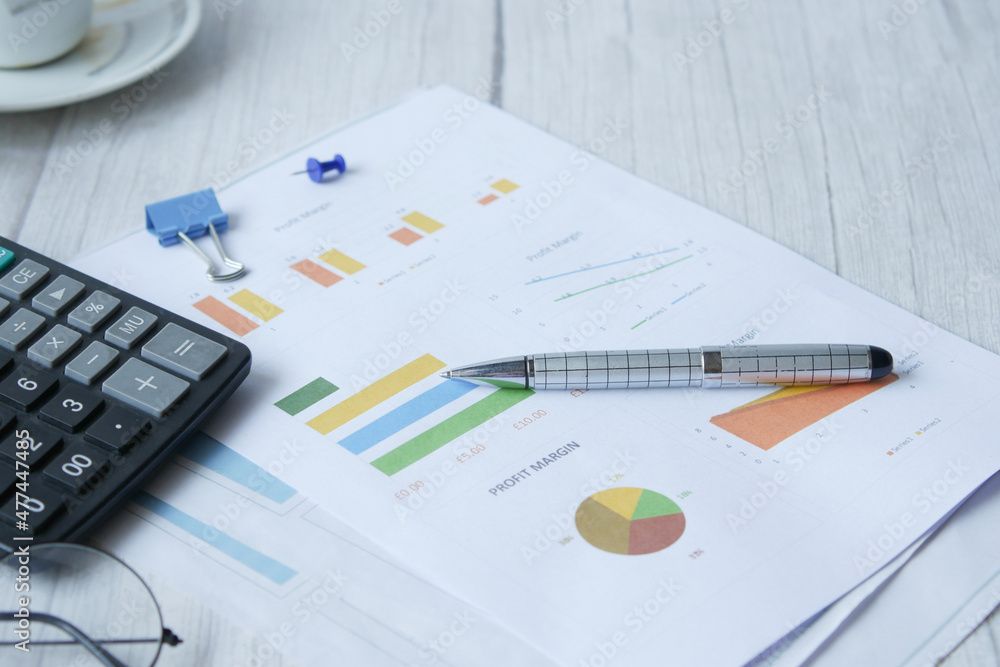 Fototapeta premium financial graph, calculator and notepad on table 