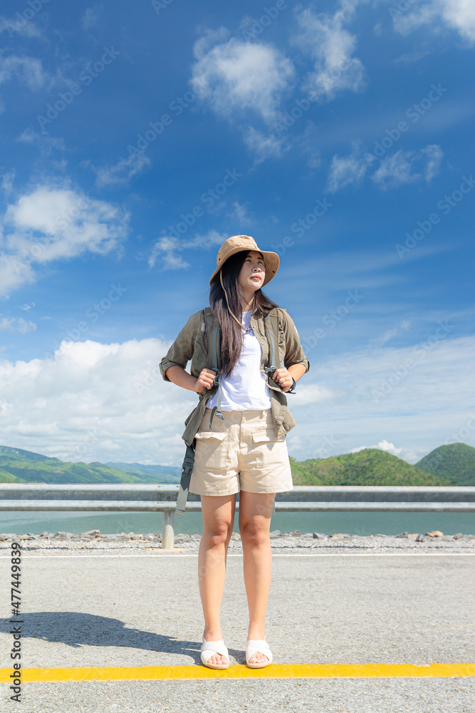 Asian girl with nature and lake,Asian girl and the lake,Asian girl standing next to beautiful lake , Relaxing,Young woman standing near the lake and reading a book while tenting outdoor on vacation