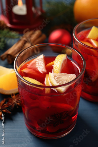 Delicious punch drink with cranberries and orange on blue wooden table