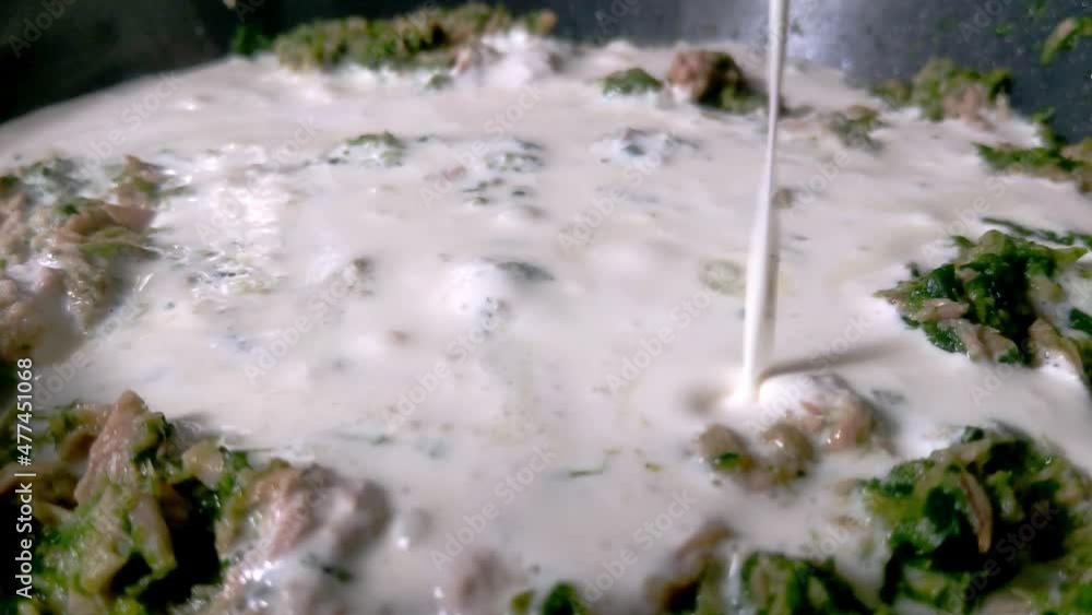 Add cream to the fish in a frying pan Add cream to the fish in a frying pan