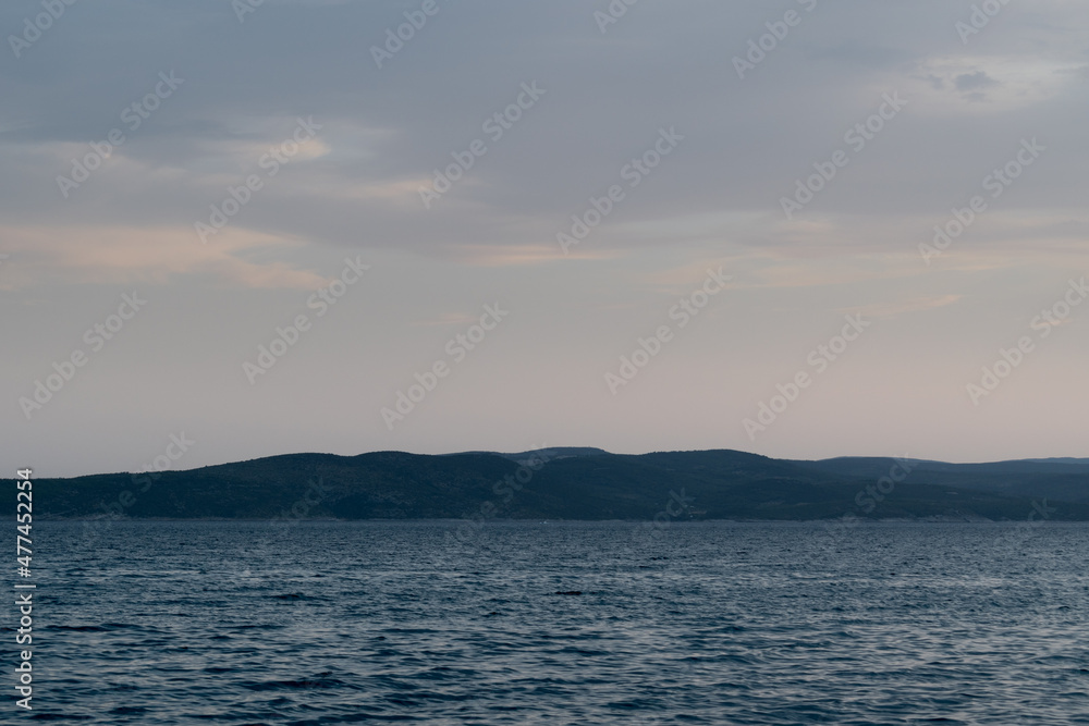 Seascape with wavy Adriatic sea and Brac island silhouette in Croatia at dusk