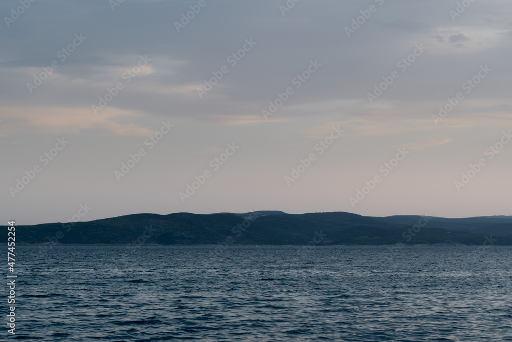 Seascape with wavy Adriatic sea and Brac island silhouette in Croatia at dusk Seascape with wavy Adriatic sea and Brac island silhouette in Croatia at dusk