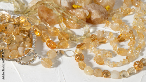Photos Variety of transparent natural yellow  citrine jewelry on a white plastered background
