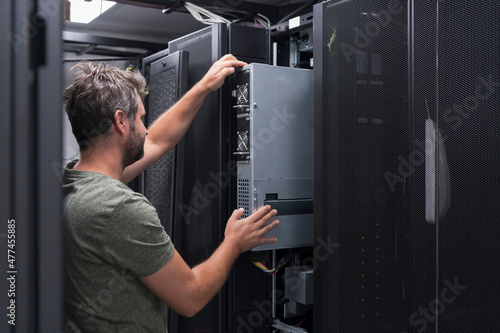 Foto IT engineer working In the server room or data center The technician puts in a rack a new server of corporate business mainframe supercomputer or cryptocurrency mining farm