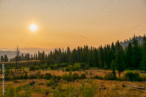 Landscape in Yellowstone National Park during sunrise with smoke from wildfires visible in the background
