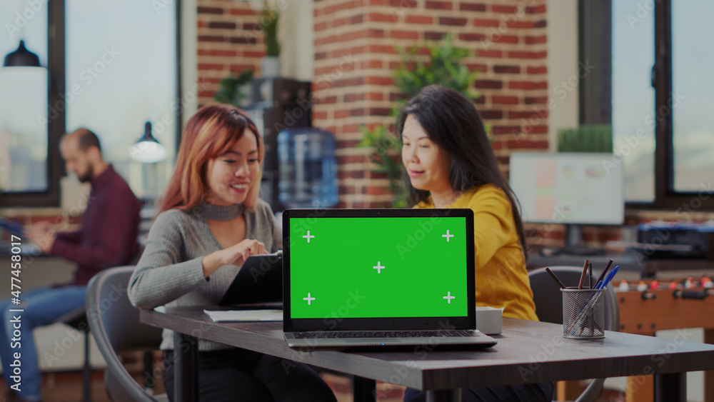 Colleagues working on business investment with green screen on laptop in office. Team of women using computer with isolated copy space and chroma key template for mockup. Blank background Colleagues working on business investment with green screen on laptop in office. Team of women using computer with isolated copy space and chroma key template for mockup. Blank background
