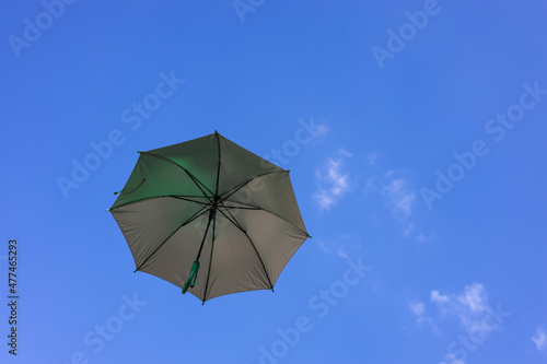 A close-up view from the low, a beautiful opaque bronze umbrella floating freely.