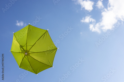 A close-up view from the low  a beautiful  translucent green umbrella floating freely.