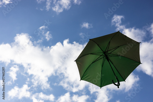 A close-up view from the low  a beautiful green umbrella floating freely.