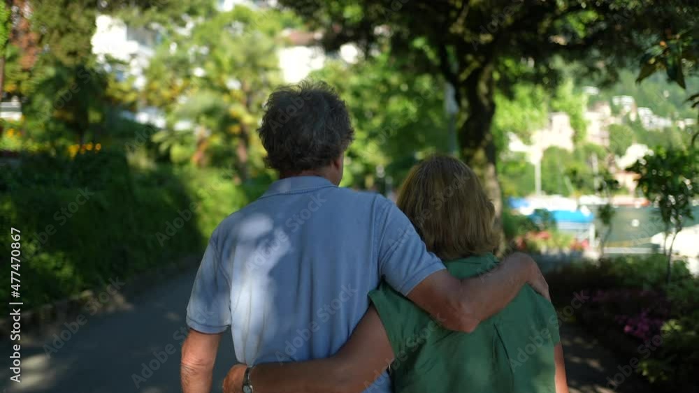 Back of senior couple walking together outside. older husband and wife afternoon walk Back of senior couple walking together outside. older husband and wife afternoon walk