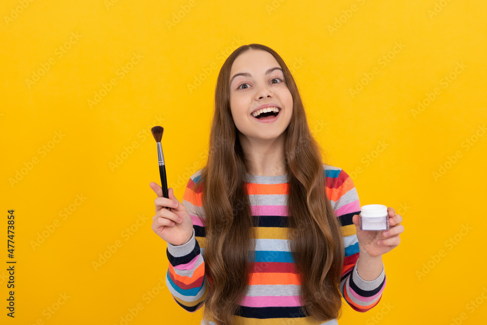 Happy kid apply cosmetics with foundation brush yellow background, makeup. Happy kid apply cosmetics with foundation brush yellow background, makeup.
