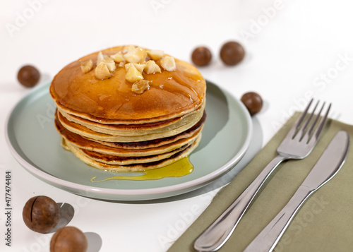 Stack of macadamia pancakes sprinkled with chopped nuts. Traditional Hawaiian dessert.