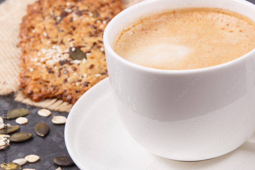 Cup of white coffee and fresh oatmeal cookies with honey and healthy seeds. Delicious crunchy dessert Cup of white coffee and fresh oatmeal cookies with honey and healthy seeds. Delicious crunchy dessert