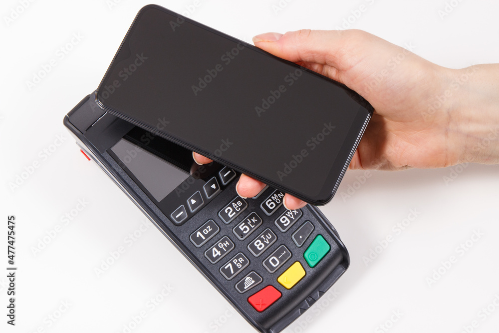 Credit card reader and mobile phone using for cashless paying. Payment terminal. Finance concept Credit card reader and mobile phone using for cashless paying. Payment terminal. Finance concept