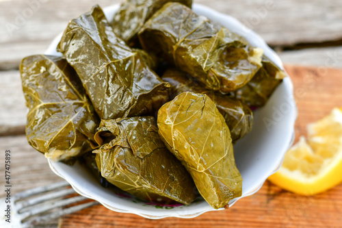 Dolmades - stuffed grape leaves  rolls  with rice the Greek way on wooden table .Stuffed greek wine leaves photo