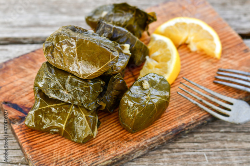 Dolmades - stuffed grape leaves  rolls  with rice the Greek way on wooden table .Stuffed greek wine leaves photo