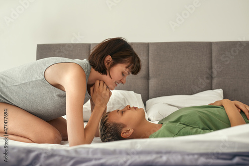 Lesbian girls rest and look at each other on bed