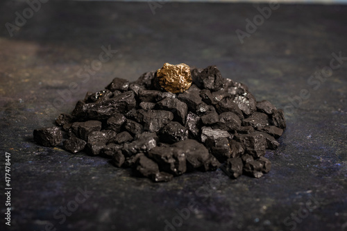 hard coal in the pile. a piece of gold among the coal. extracted underground.