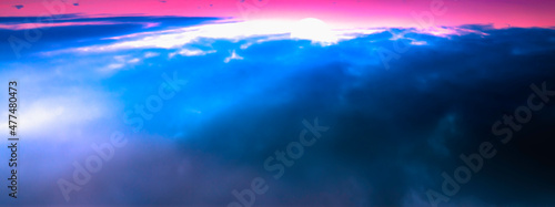 Majestic sunrise aerial view over the blue clouds on the pink sky background