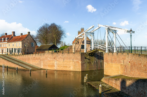 View of the white old drawbridge in the harbor of the city of Heusden surrounded by its fortified walls. photo