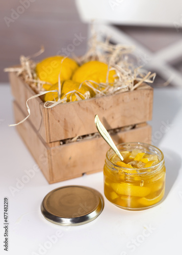 Glass jar with yuzu jam near a wooden box with citrus yuzu fruit. yuja-cheong is marmalade made from yuzu zest, juice and honey. photo