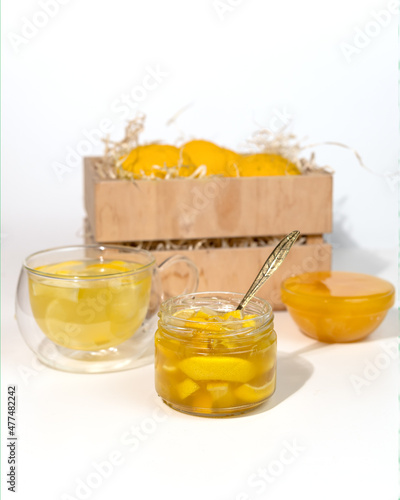 Glass jar with yuzu jam near a wooden box with citrus yuzu fruit. yuja-cheong is marmalade made from yuzu zest, juice and honey. photo