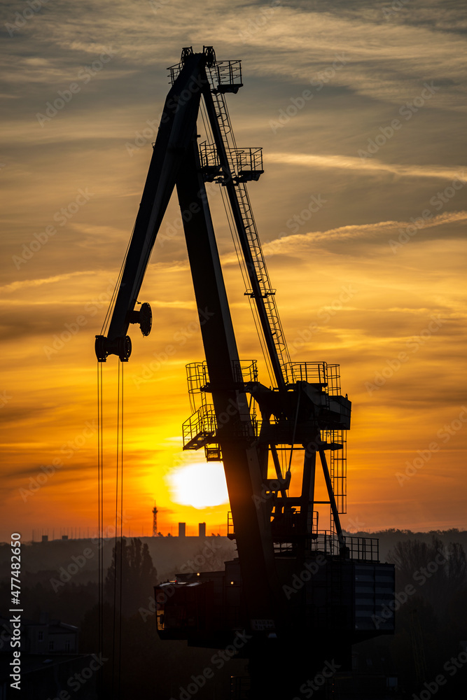 Kran an der Havel entlädt im Hafen ein Schiff im Sonnenaufgang. Kran an der Havel entlädt im Hafen ein Schiff im Sonnenaufgang.