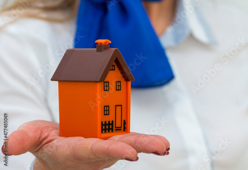 Real estate agent girl with model of a house foreground