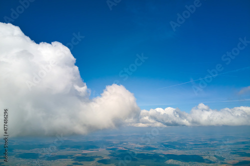 Картината върху платно Aerial view from airplane window at high altitude of earth covered with puffy cu