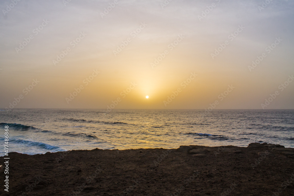 Coucher de soleil devant un falaise