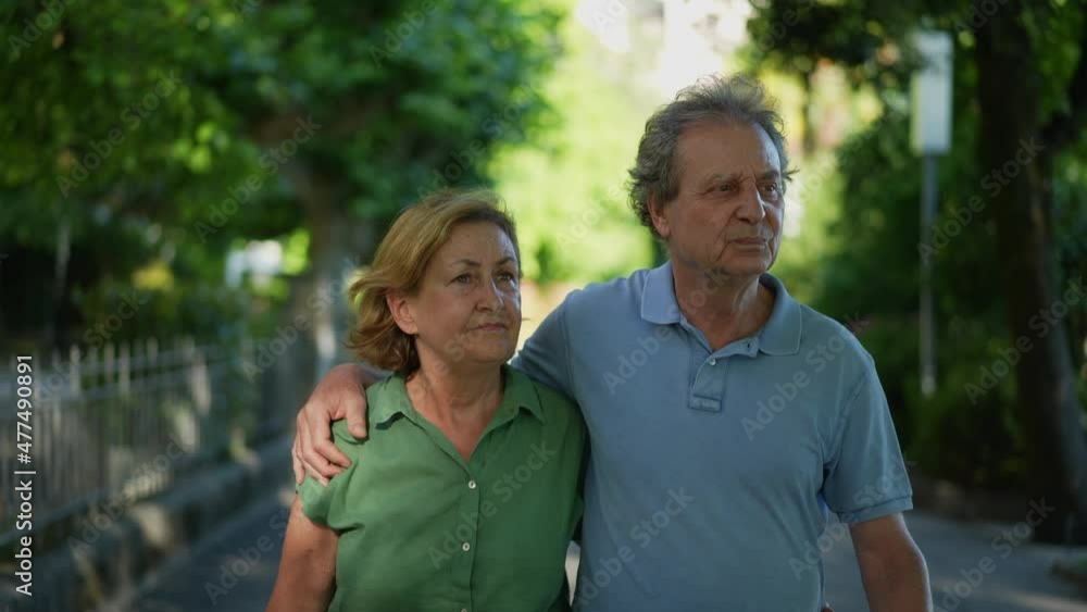 Happy senior couple walking together in green path outside Happy senior couple walking together in green path outside