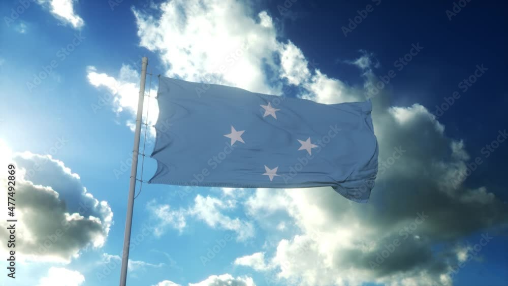 Federated State of Micronesia flag waving at wind against beautiful blue sky Federated State of Micronesia flag waving at wind against beautiful blue sky